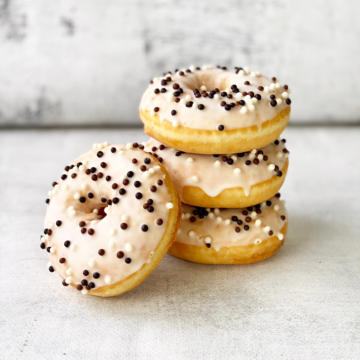 Пончик-донатс с ванильной начинкой, белой кондитерской глазурью с шоколадными шариками  изображение 2