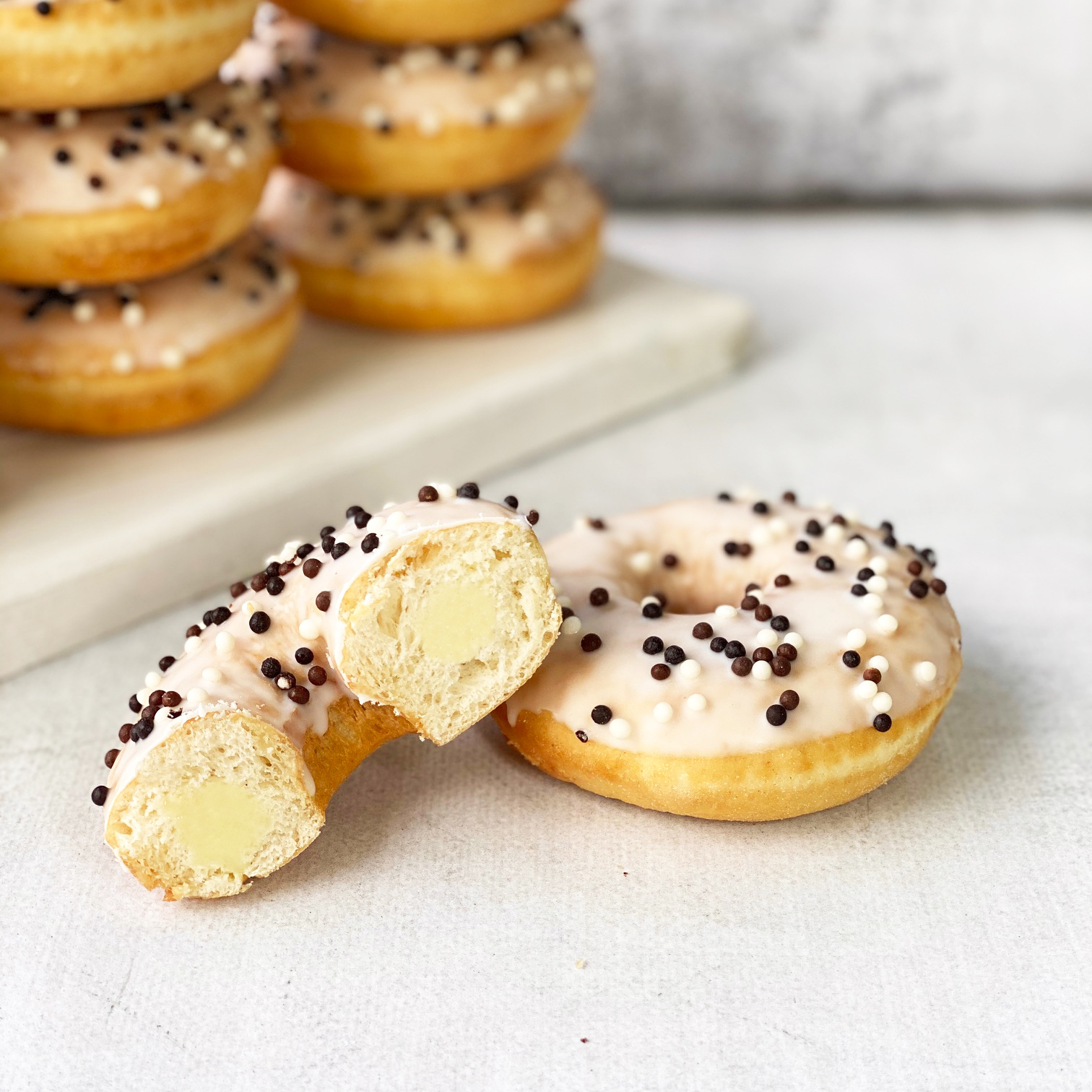 Пончик-донатс с ванильной начинкой, белой кондитерской глазурью с шоколадными шариками  изображение 3