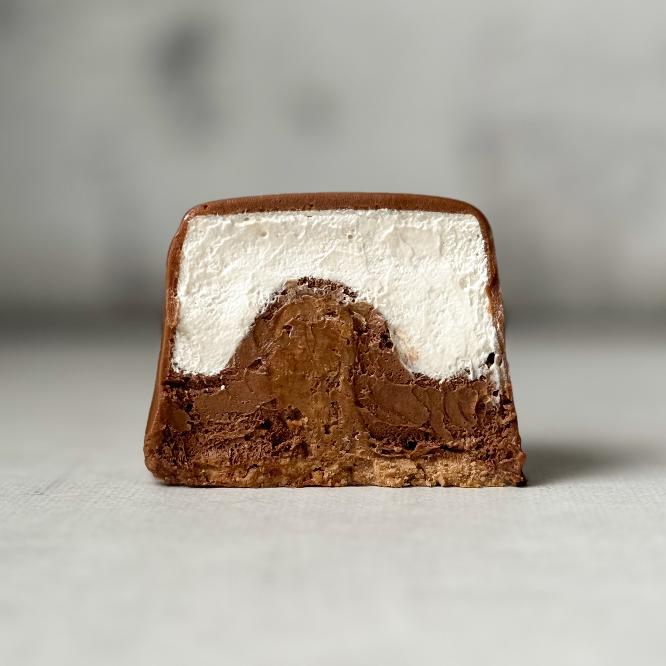Два слоя из белого и молочного шоколада с хрустящей сердцевиной из фундучного пралине, покрыто молочным шоколадом. изображение 2
