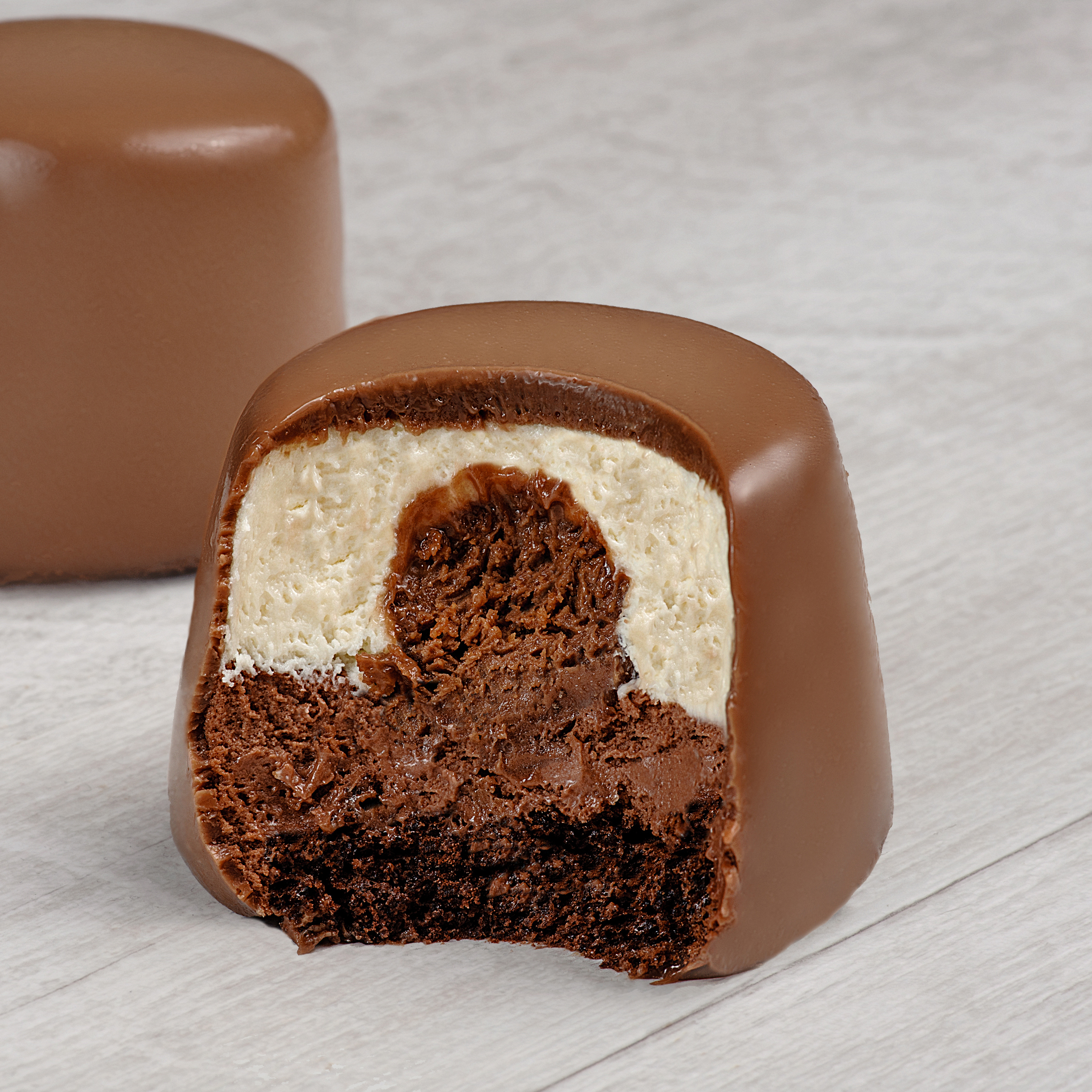 Два слоя из белого и темного шоколада с хрустящей сердцевиной из фундучного пралине, покрыто темным шоколадом. изображение 1