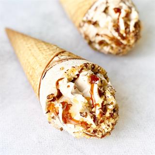 Мороженое сливочное с ароматом грецкого ореха, декорированное кленовым сиропом и грецким орехом в сахарном вафельном рожке с шоколадной глазурью